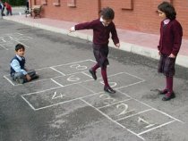 3 children playing hopscotch