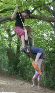 Two children on a tree swing trapeze